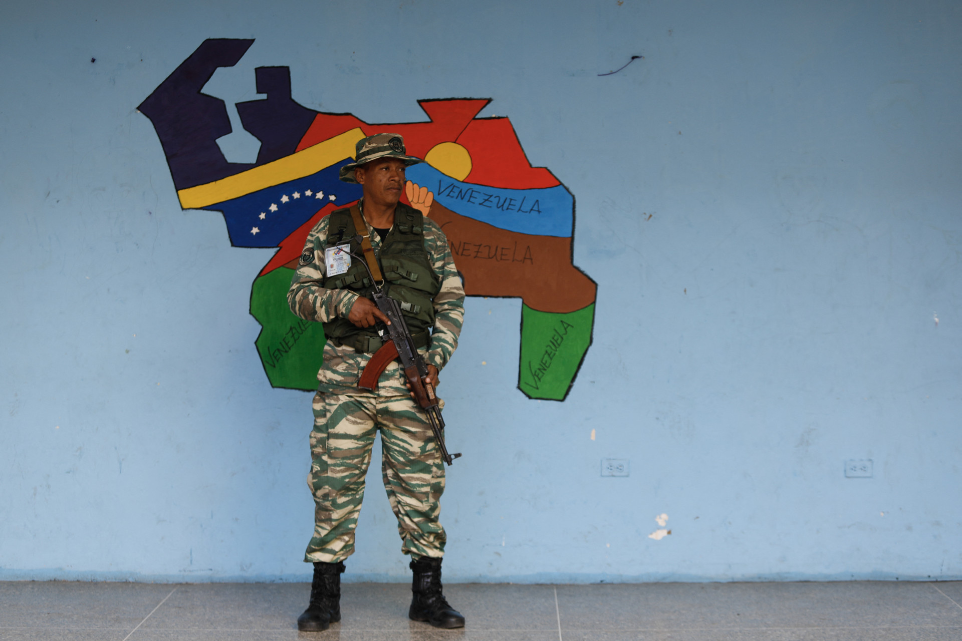 Um membro das Milícias Bolivarianas monta guarda em uma seção eleitoral durante um referendo consultivo sobre a soberania venezuelana sobre a região de Essequibo controlada pela vizinha Guiana, em Caracas, em 3 de dezembro de 2023(Foto: PEDRO RANCES MATTEY / AFP)