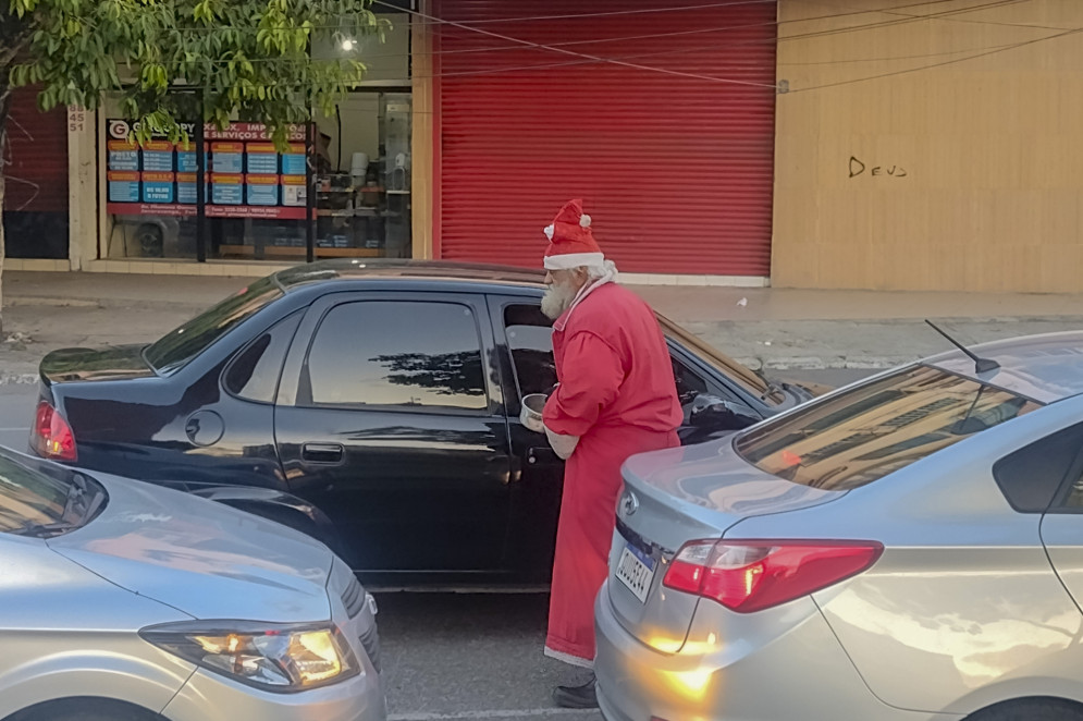 Quando as pernas permitem, o Papai Noel transita entre os carros para buscar algumas moedas ou cédulas(Foto: Cláudio Ribeiro)