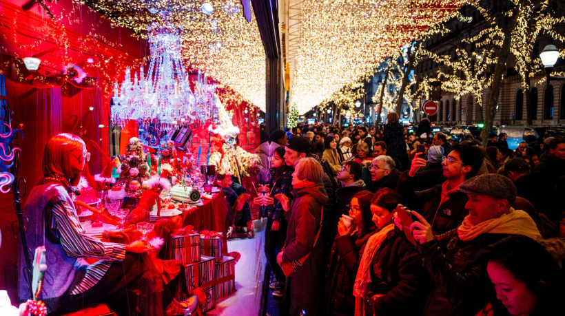 Público observa vitrines nas Galerias Lafayette exibindo decorações de Natal em Paris, França