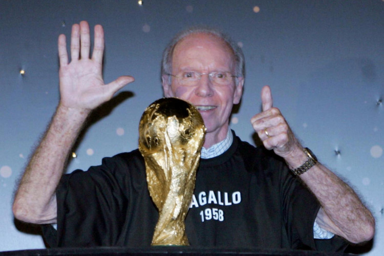 O ex-futebolista brasileiro Mario Jorge Lobo Zagallo, integrante das seleções nacionais que venceu as Copas do Mundo de 1958, 1962, 1970 e 2002, posa atrás do troféu da FIFA em 19 de janeiro de 2006 no Forte Copacabana, Rio de Janeiro, Brasil, mostrando seis dedos para simbolizar o desejo do Brasil de conquistar pela sexta vez a taça na próxima Copa do Mundo Alemanha 2006. O troféu permanecerá exposto ao público na sexta-feira e depois seguirá para São Paulo. FOTO AFP CAIO MARCELO