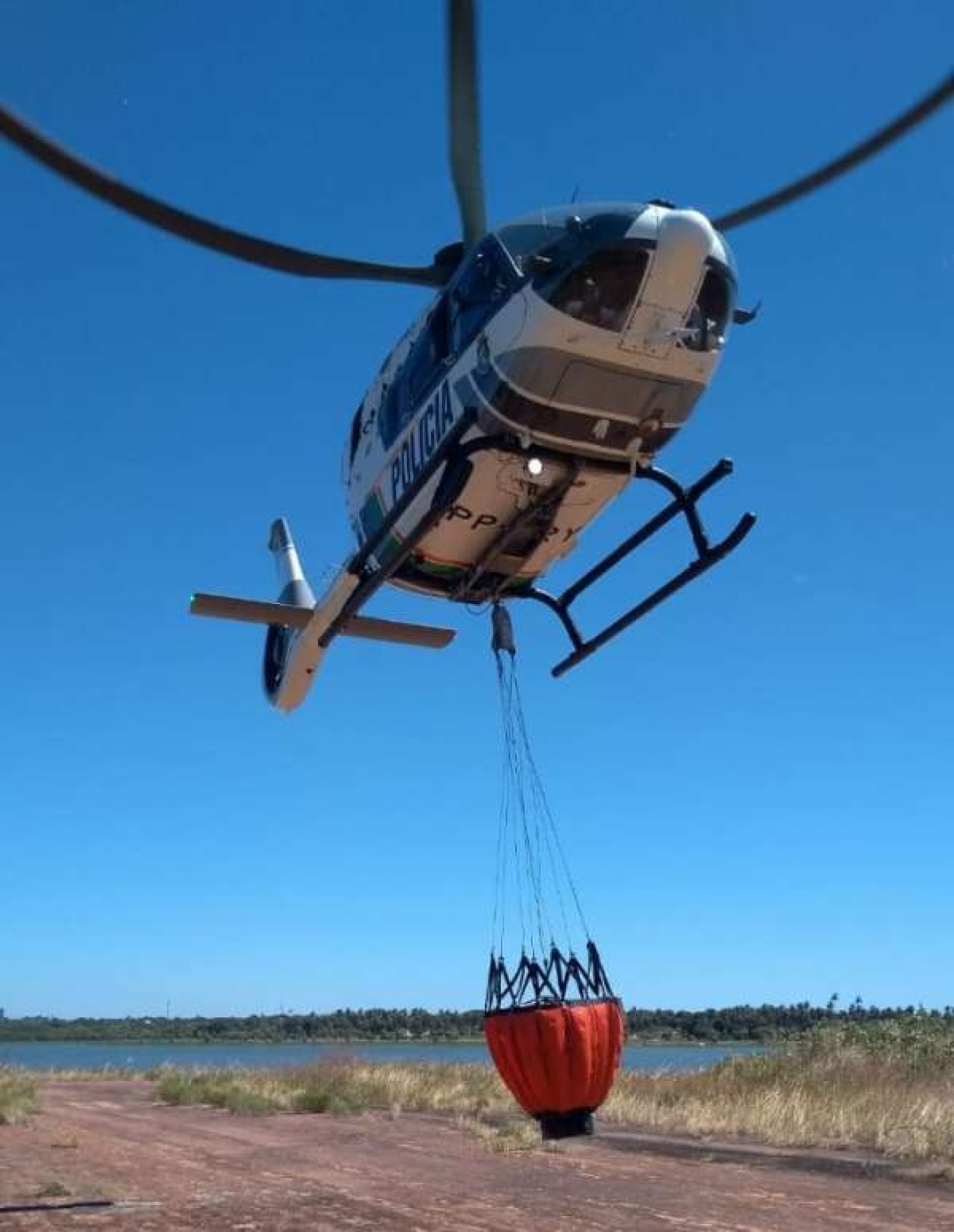 Helicóptero da Ciopaer com o Bambi Bucket acoplado. Equipamento tem capacidade de despejar 500 litros de água por vez em focos de queimada(Foto: SSPDS/Divulgação)