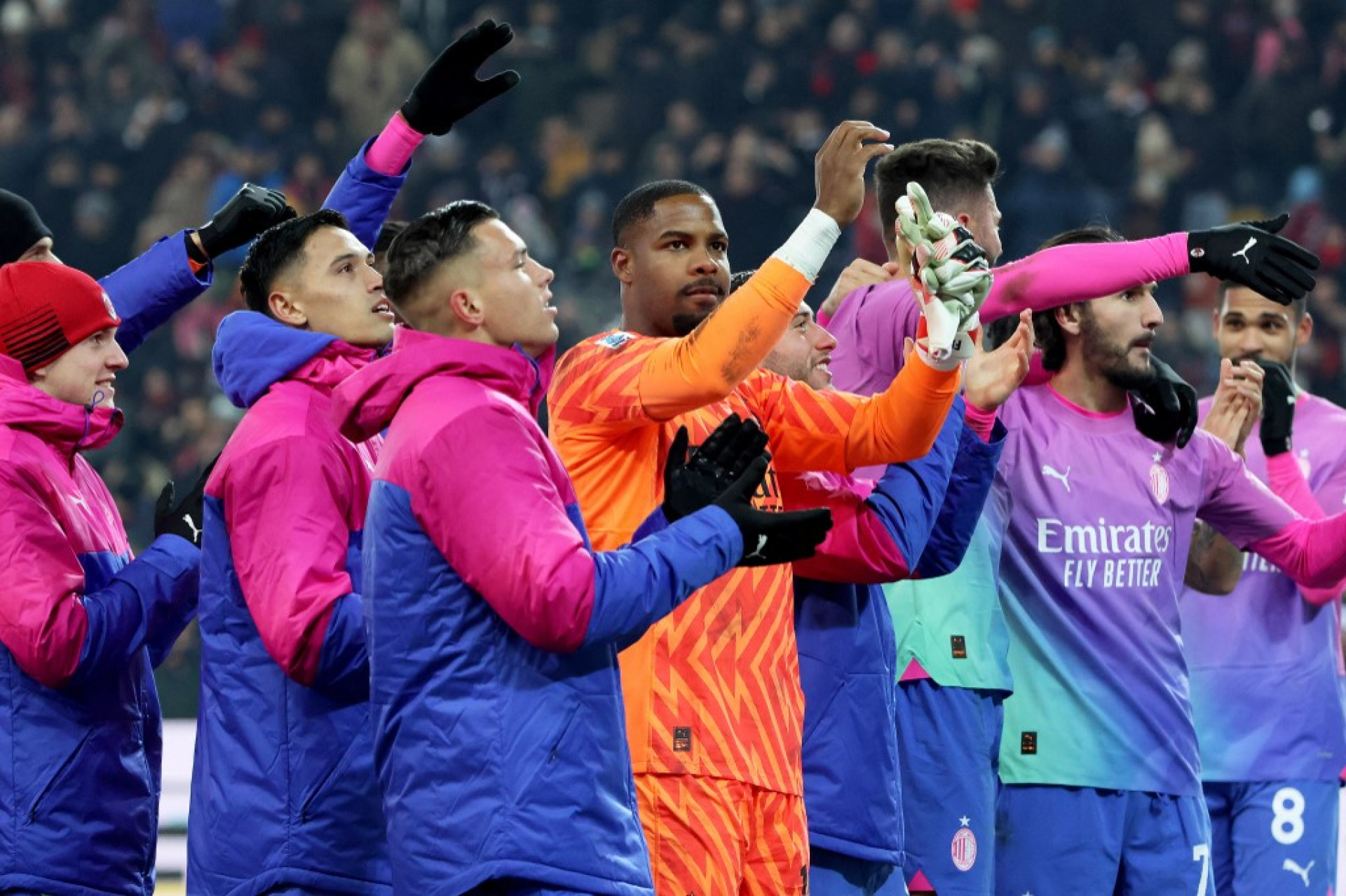 O goleiro francês do Milan comemora com os companheiros após vencer a partida de futebol da Série A italiana Udinese Calcio x AC Milan no estádio Friuli - Dacia Arena em Udine, em 20 de janeiro de 2024. O AC Milan se recuperou de uma desvantagem de gol para vencer a Udinese por 3 a 2 em em uma partida que foi brevemente suspensa por Mike Maignan ter sido abusado racialmente por torcedores da casa. A partida foi marcada por gritos de macacos dirigidos a Maignan por parte de um grupo de torcedores da Udinese que indignaram o goleiro francês. O jogo foi interrompido no final do primeiro tempo pelo árbitro Fabio Maresca após persistentes abusos racistas contra Maignan, que saiu de campo ao lado de seus companheiros. (Foto: GABRIELE MENIS / ANSA / AFP)