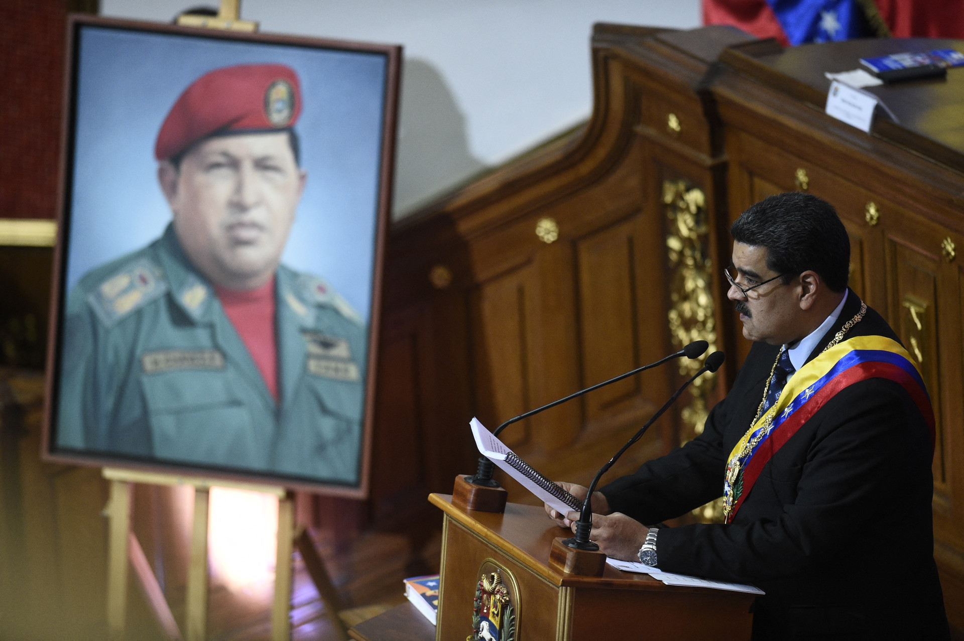 ￼NICOLÁS Maduro fala à Assembleia Constituinte diante de um retrato de Hugo Chávez (Foto: Federico PARRA/AFP)