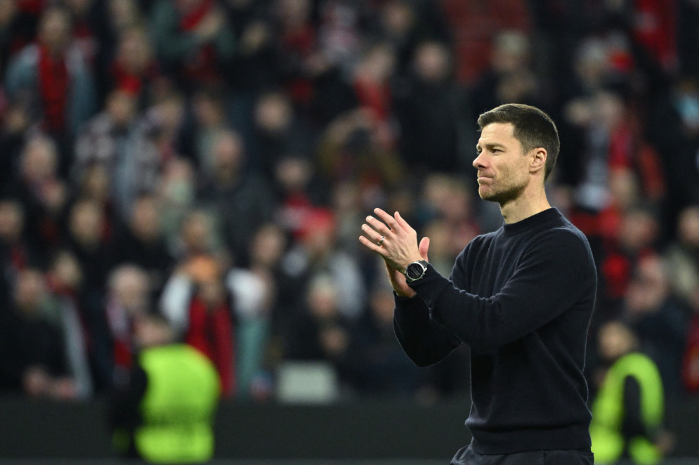 Xabi Alonso aplaude atuação do elenco à beira do gramado do estádio BayArena, casa do Bayer Leverkusen(Foto: INA FASSBENDER / AFP)