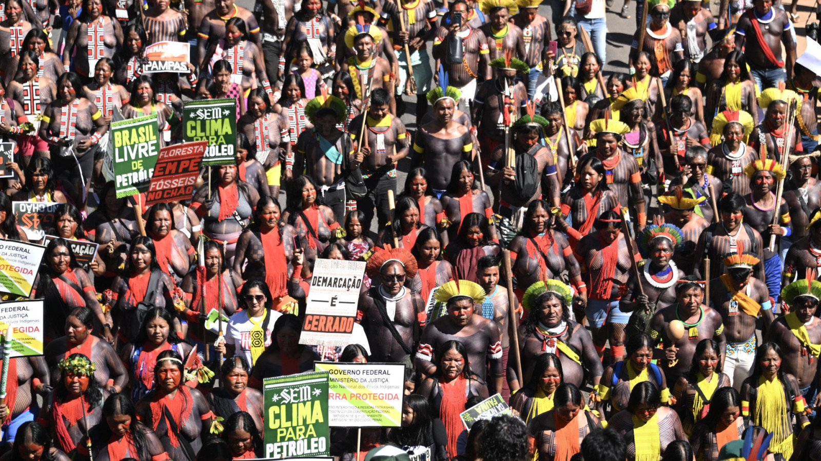 Indígenas brasileiros marcham em Brasília como parte do Acampamento Terra Livre em 23 de abril de 2024. Entre os cartazes, dizeres como 'Sem clima para petróleo' e 'Floresta em pé, fósseis no chão'. (Foto: EVARISTO SA / AFP)