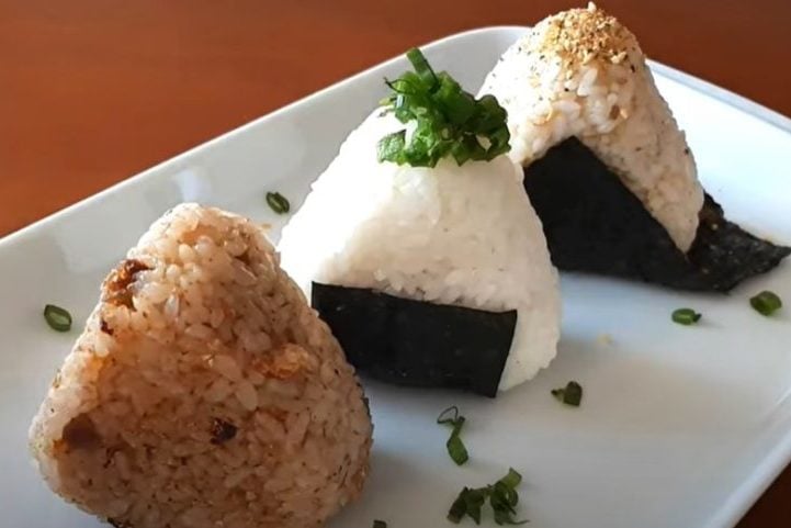 Onigiri: Bolinho de arroz recheado com diversos ingredientes, como salmão, atum, umeboshi ou furikake. Uma opção prática para lanches ou refeições rápidas.