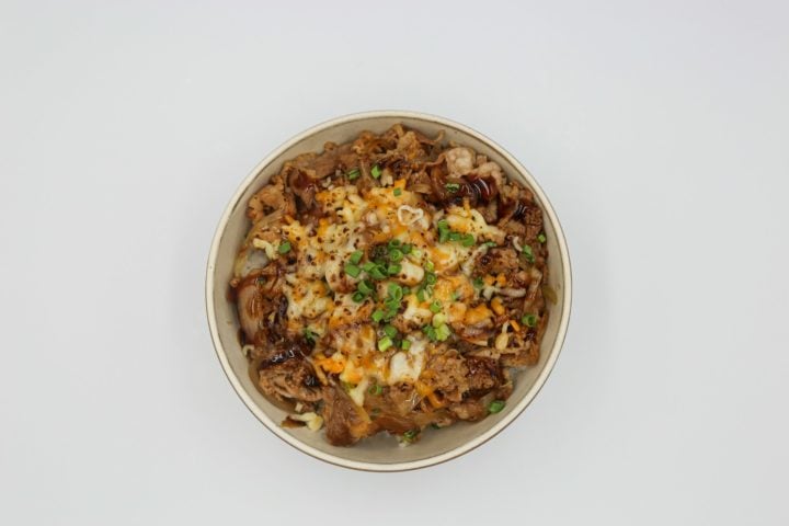 Donburi: Tigela de arroz com diversos acompanhamentos, como carne, frango, frutos do mar, legumes e ovo. Uma refeição completa e nutritiva.