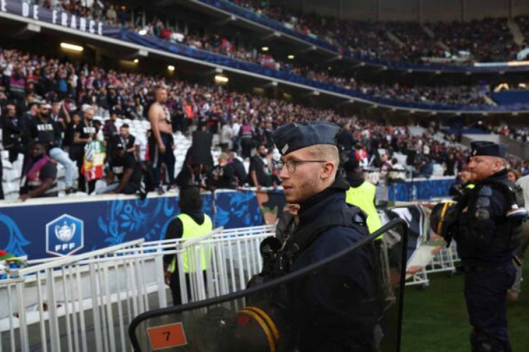 French CRS riot police face fans in the stands from the edge of the pitch ahead of the French Cup Final football match between Olympique Lyonnais (OL) and Paris Saint-Germain (PSG) at the Stade Pierre-Mauroy, in Villeneuve-d'Ascq, northern France on May 25, 2024. (Photo by FRANCK FIFE / AFP) (Photo by FRANCK FIFE/AFP via Getty Images)