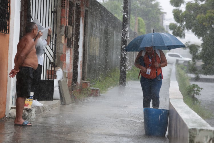 FORTALEZA, CEARÁ, BRASIL,29.05.2024:  Homem toma banho de bica durante chuva em Fortaleza. Jardim América.