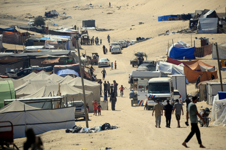 Palestinos deslocados caminham entre tendas em Rafah, no sul da Faixa de Gaza, em 31 de maio de 2024, em meio ao conflito em curso entre Israel e o grupo palestino Hamas.