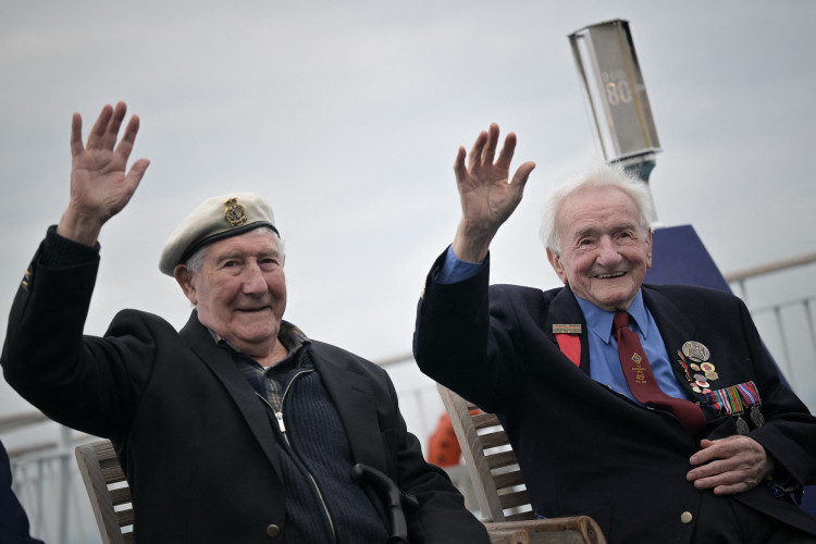 Os veteranos da Marinha Real do Reino Unido Roy Harrison (esquerda) e Albert Keir, 98, acenam durante uma viagem à França na balsa Brittany Ferries, perto de Portsmouth, sul da Inglaterra, em 4 de junho de 2024, como parte das comemorações que marcam o 80º aniversário do desembarque dos Aliados na Segunda Guerra Mundial na Normandia(Foto: Lou BENOIST / AFP)