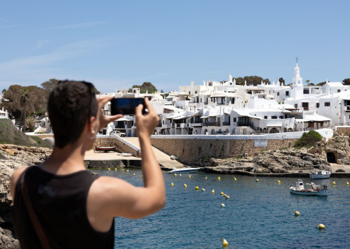 Turista tira uma foto de Binibeca, uma pequena vila de pescadores, no município de Sant Lluis, na ilha balear de Menorca