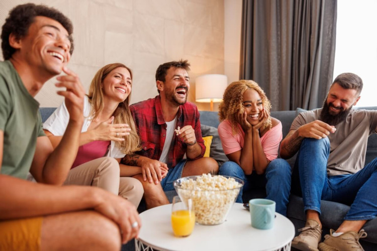 Aproveitar o fim de semana para assistir a filmes de comédia pode ser uma boa pedida para relaxar (Imagem: Impact Photography | Shutterstock)