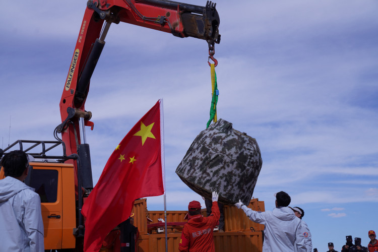Autoridades carregam o módulo de pouso da sonda lunar Chang'e-6 em um caminhão depois que ela pousou no norte da China