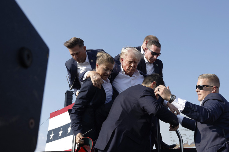 O candidato presidencial republicano, ex-presidente Donald Trump, é levado para fora do palco durante um comício em 13 de julho de 2024 em Butler, Pensilvânia 