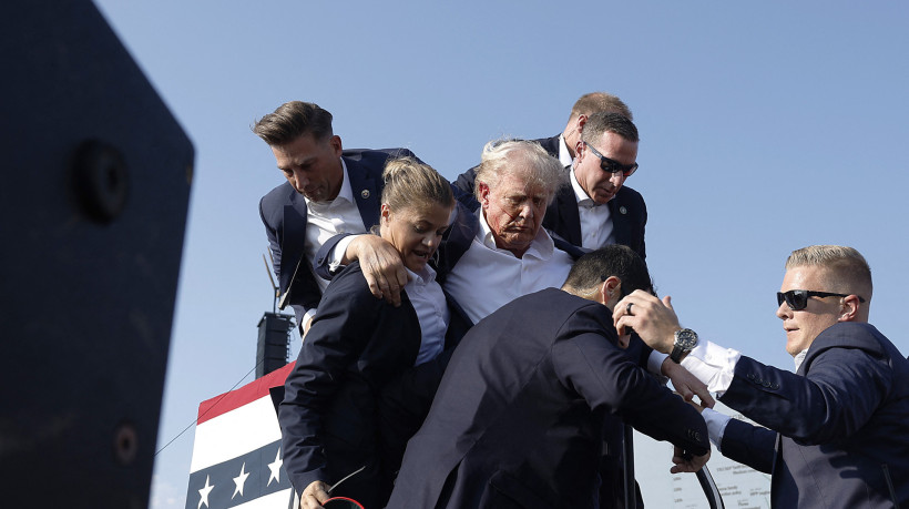 O candidato presidencial republicano, ex-presidente Donald Trump, é levado para fora do palco durante um comício em 13 de julho de 2024 em Butler, Pensilvânia  