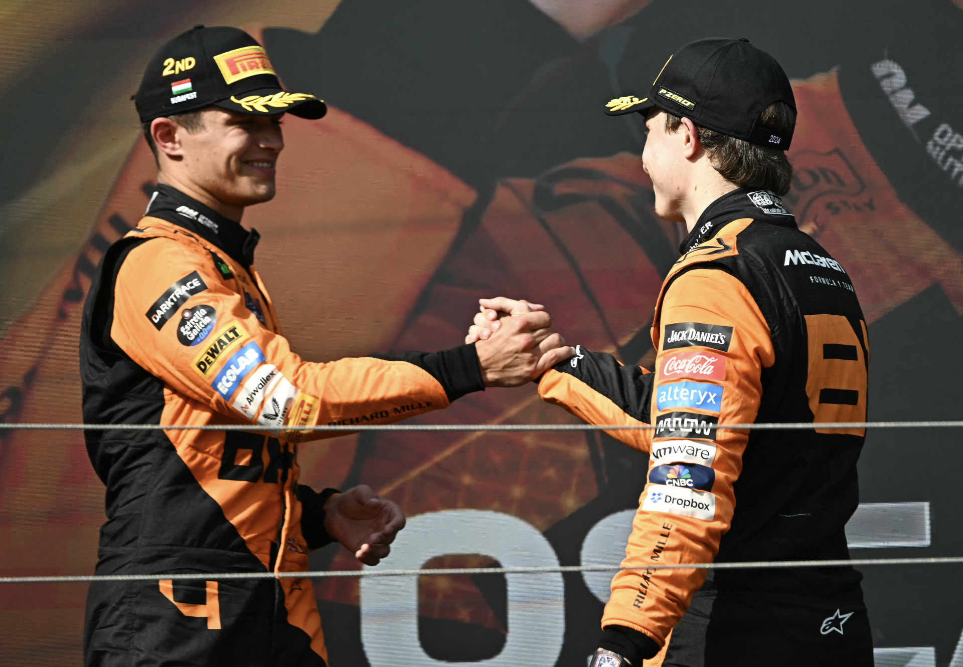 O piloto australiano da McLaren, Oscar Piastri (R), é parabenizado pelo piloto britânico da McLaren, Lando Norris, pelo pódio após o Grande Prêmio da Hungria de Fórmula 1 no autódromo de Hungaroring, em Mogyorod, perto de Budapeste, em 21 de julho de 2024. (Foto: Attila KISBENEDEK/AFP)