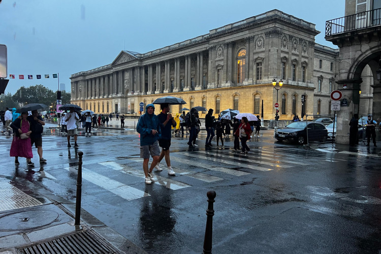 Público caminha sob a chuva em Paris durante a cerimônia de abertura das Olimpíadas