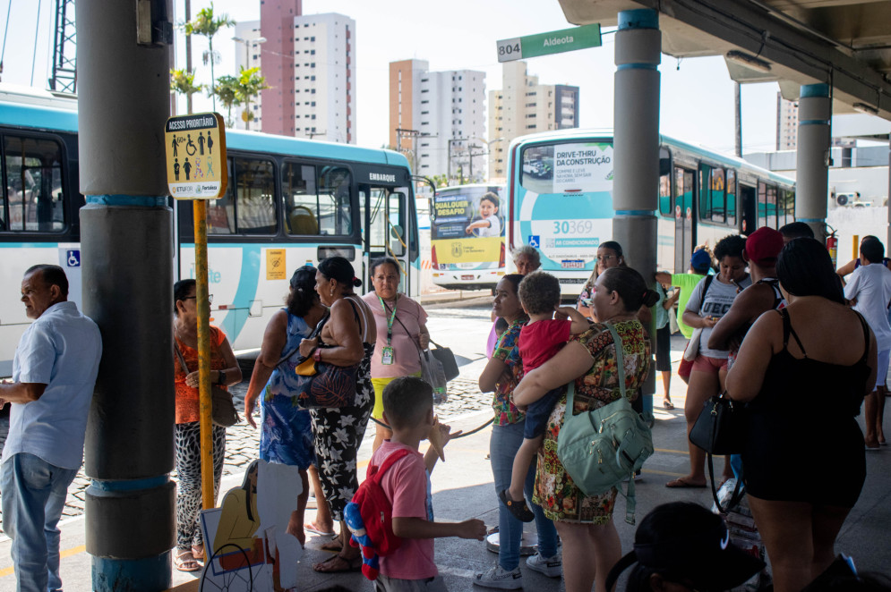 Passageiros em fila esperam ônibus em uma plataforma do terminal. Ao fundo, dois coletivos nas cores azul e branco se dirigem à porta de saída(Foto: Samuel Setubal)