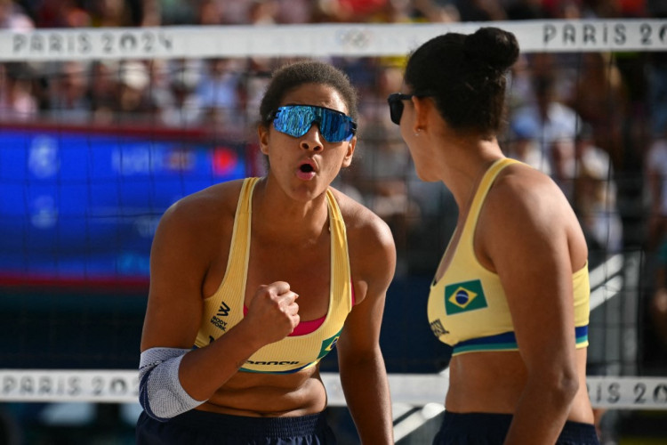 A brasileira #01 Ana Patricia Silva Ramos (E) e a brasileira #02 Eduarda Santos Lisboa comemoram um ponto na partida de vôlei de praia feminino das quartas de final entre Brasil e Letônia durante os Jogos Olímpicos de Paris 2024 no Estádio da Torre Eiffel em Paris em 7 de agosto de 2024