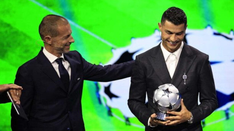 Portugal's national team player and Saudi Al-Nassr's forward Cristiano Ronaldo (R) receives the All-Time Goalscorer Award in the UEFA Champions League from UEFA President Aleksander Ceferin during the ceremony of the draw for the group stage of the 2024-2025 UEFA Champions League football tournament, at the Grimaldi Forum in Monaco on August 29, 2024. (Photo by Valery HACHE / AFP) (Photo by VALERY HACHE/AFP via Getty Images)