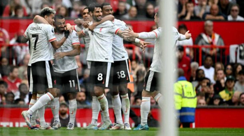 Liverpool's Egyptian striker #11 Mohamed Salah (2L) celebrates with teammates after scoring the team's third goal during the English Premier League football match between Manchester United and Liverpool at Old Trafford in Manchester, north west England, on September 1, 2024. (Photo by Paul ELLIS / AFP) / RESTRICTED TO EDITORIAL USE. No use with unauthorized audio, video, data, fixture lists, club/league logos or 'live' services. Online in-match use limited to 120 images. An additional 40 images may be used in extra time. No video emulation. Social media in-match use limited to 120 images. An additional 40 images may be used in extra time. No use in betting publications, games or single club/league/player publications. /  (Photo by PAUL ELLIS/AFP via Getty Images)