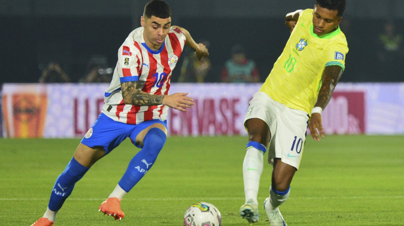 Rodrygo (à direita), do Brasil, disputando espaço com Almirón (à esquerda), do Paraguai, em jogo válido pelas Eliminatórias da Copa do Mundo