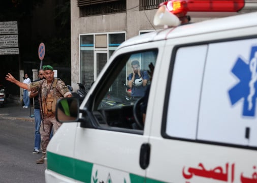 Soldado libanês gesticula para ambulância que leva pessoas feridas a hospital em Beirute em 17 de setembro de 2024, depois que explosões atingiram locais em vários redutos do Hezbollah ao redor do Líbano em meio às contínuas tensões transfronteiriças entre Israel e combatentes do Hezbollah