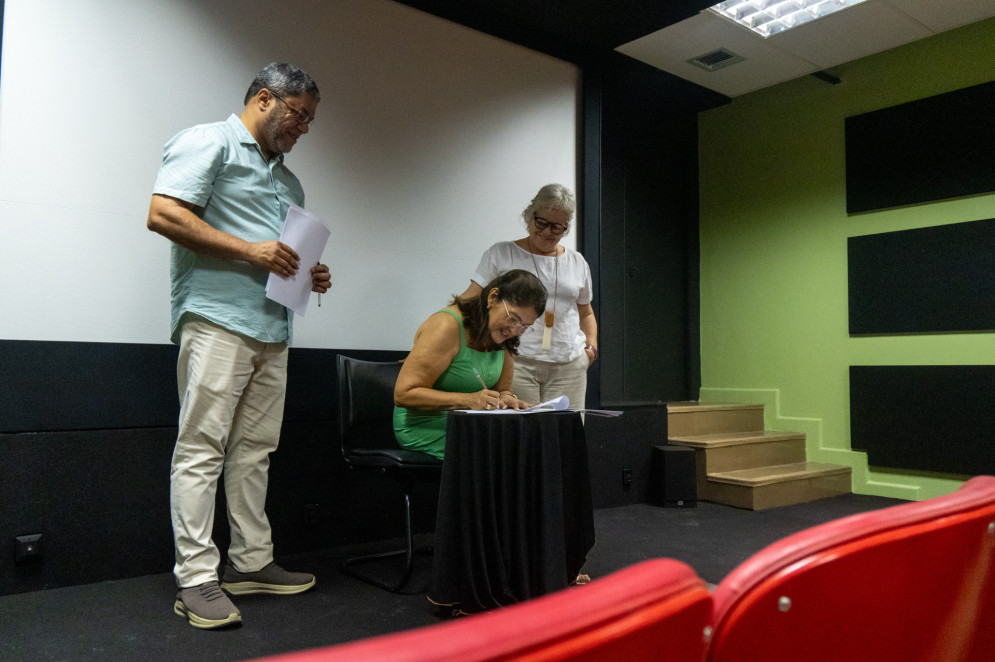 Iris Machado, filha de Seu Vavá, assina o termo de comodato junto ao Instituto Dragão do Mar, doando o acervo do pai para a gestão cultural do Estado(Foto: Hygor Linhares/ Cineteatro São Luiz)