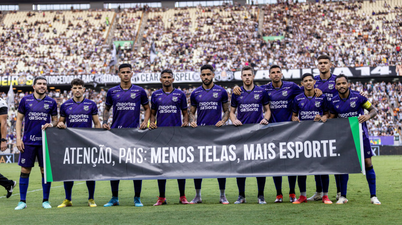 Jogadores do Ceará carregam faixa alertando sobre o uso excessivo de telas