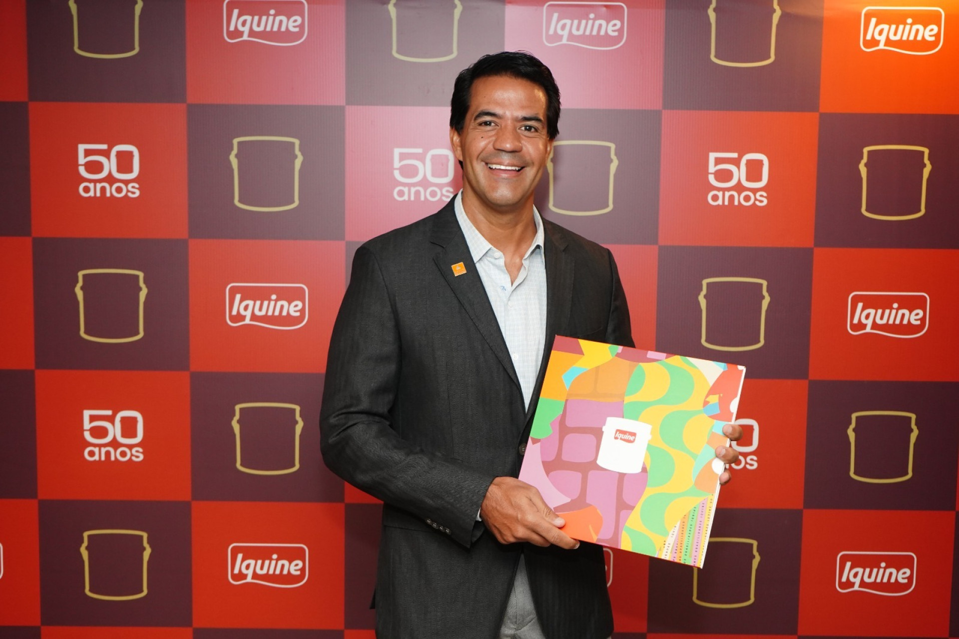 O presidente do Conselho de Administração do Grupo Iquine, Alan Souza, com o livro "As Cores da Transformação", que reúne relatos de 50 pessoas impactadas pelos produtos e pela atuação cultural e social da marca (Foto: LEANDRO LIMA-DIVULGAÇÃO)