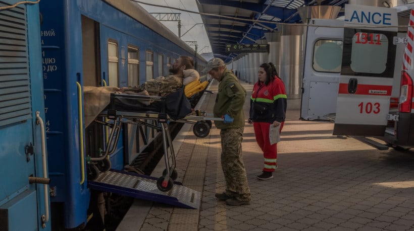 Um soldado ucraniano ferido é transferido em uma maca de ambulâncias para um trem de evacuação militar que transporta militares ucranianos feridos em áreas da linha de frente para hospitais, em local não revelado, em 18 de outubro de 2024, em meio à invasão russa da Ucrânia