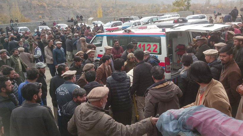 Fotografia tirada e divulgada pelo Serviço de Emergência Gilgit-Baltistan do Paquistão. Pessoas carregam corpo de um falecido que morreu em um acidente de ônibus de casamento em Gilgit.