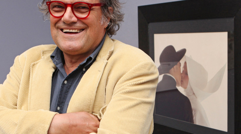 O fotógrafo italiano Oliviero Toscani à frente de uma da obra 