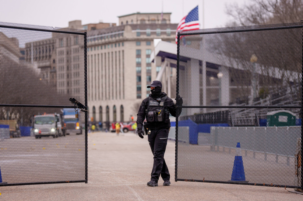 Membro do Serviço Secreto dos Estados Unidos fecha portão de segurança próximo ao local da parada de posse de Donald Trump, na avenida Pennsylvania, na parte norte da Casa Branca(Foto: Andrew Harnik / GETTY IMAGES NORTH AMERICA / Getty Images via AFP)