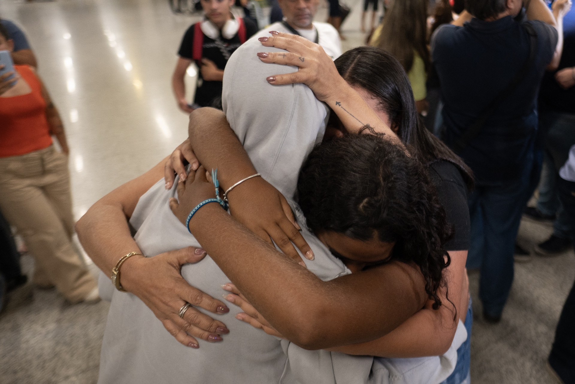 ￼HOMEM deportado dos EUA é recebido por parentes em aeroporto de Minas Gerais (Foto: Douglas MAGNO / AFP)