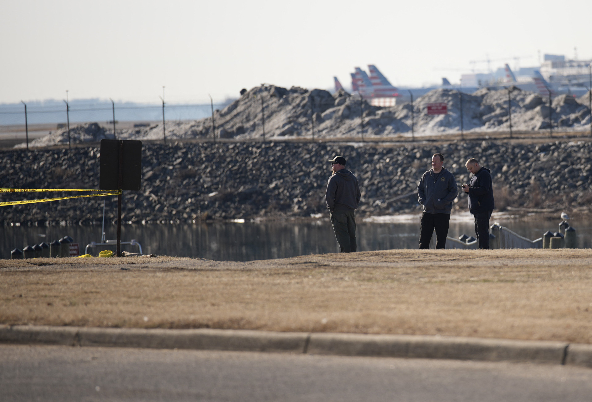 Pessoas olham para o local do acidente do avião da American Airlines no rio Potomac enquanto se aproximava do Aeroporto Nacional Reagan em 30 de janeiro de 2025 em Arlington, Virgínia (Foto: Andrew Harnik / Getty Images via AFP)