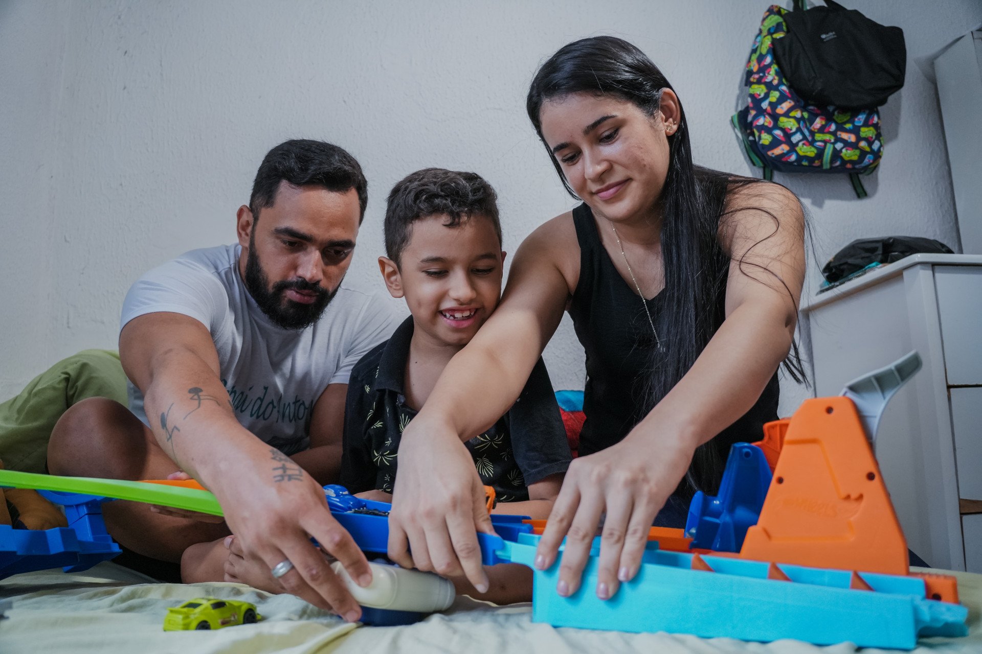 O garoto Antonne, 
de 8 anos, brincando com a mãe Karoline Alves e com o pai Alexandre Rosa (Foto: FERNANDA BARROS)