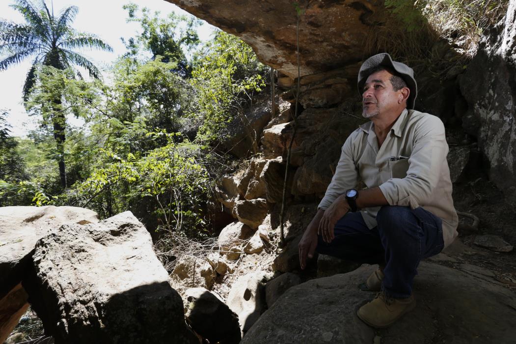 Álamo Feitosa Saraiva, paleontólogo da Urca, no Geossítio Ponte de Pedra, mostrando uma geoforma esculpida no arenito, resultado da erosão causada pela água ao longo dos últimos milhões de anos, que resultou na ponte de pedra, período cretáceo(Foto: TATIANA FORTES)