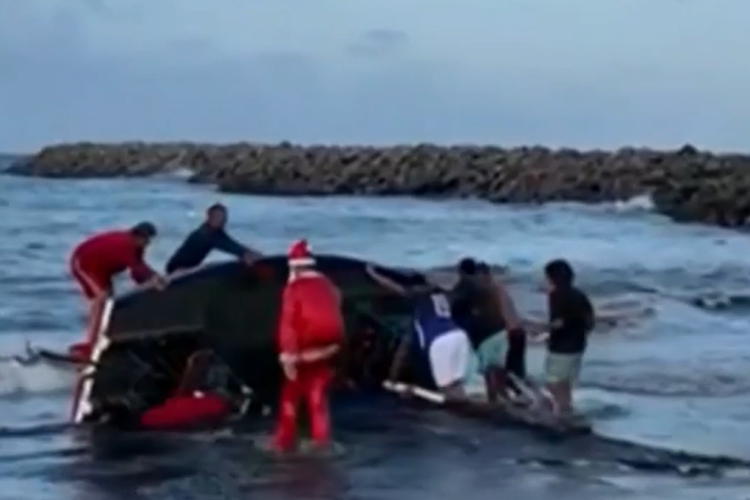 Vídeo mostra o momento em que o Papai Noel tomba com a embarcação ao se aproximar da faixa de areia
