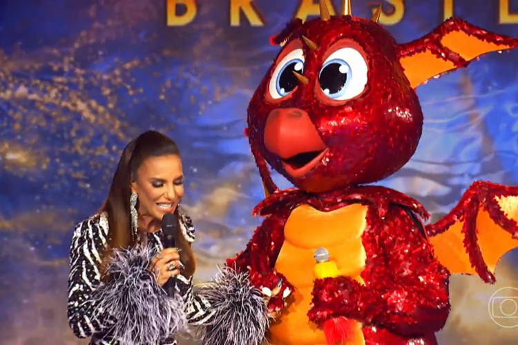 Ivete Sangalo ao lado do Dragão do The Masked Singer Brasil; hoje, 6 de fevereiro (06/02) jurados tentam descobrir quem é o personagem no reality musical. Veja as dicas e os palpites dos jurados e vote na enquete