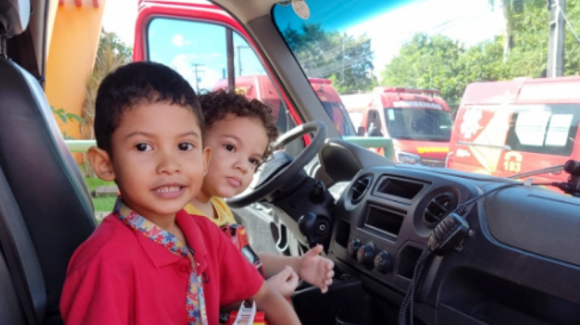 Moisés, segurando o caminhão de brinquedo, deu uma volta em uma viatura usada pelos bombeiros 