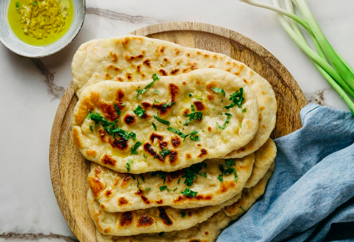 7º) Butter Garlic Naan (Índia) - Esse prato é um tipo de pão indiano feito com uma massa fermentada e enriquecida com manteiga e alho. É frequentemente servido com curry, chutneys ou molhos.