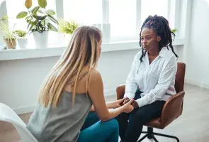 Uma mulher com as duas mãos no seu coração